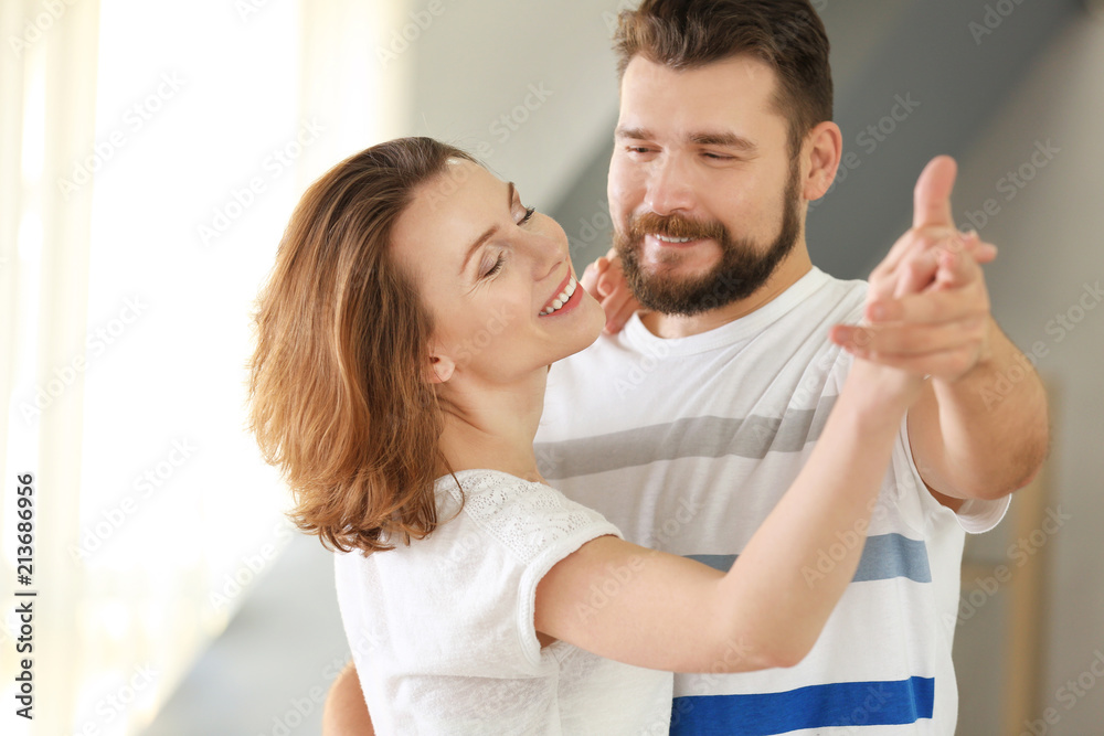 Fototapeta premium Lovely couple dancing together at home