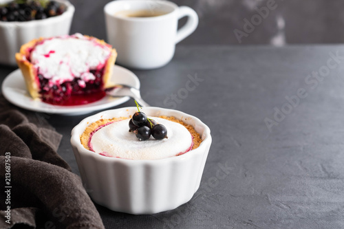 Pie with fruit and berry filling and meringue with a cup of coffee on a black background. photo