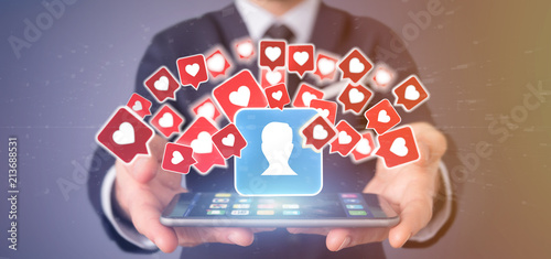 Fotografie Businessman holding  Like notification on a contact on a social media 3d renderi