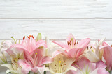 Flat lay composition with beautiful blooming lily flowers on wooden background