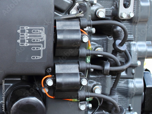 Obraz na płótnie Wiring diagram, ignition coils and high voltage wires with tips on four-cylinder outboard motor w salonie