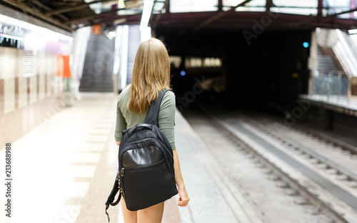 Woman is standing on platform and waiting train