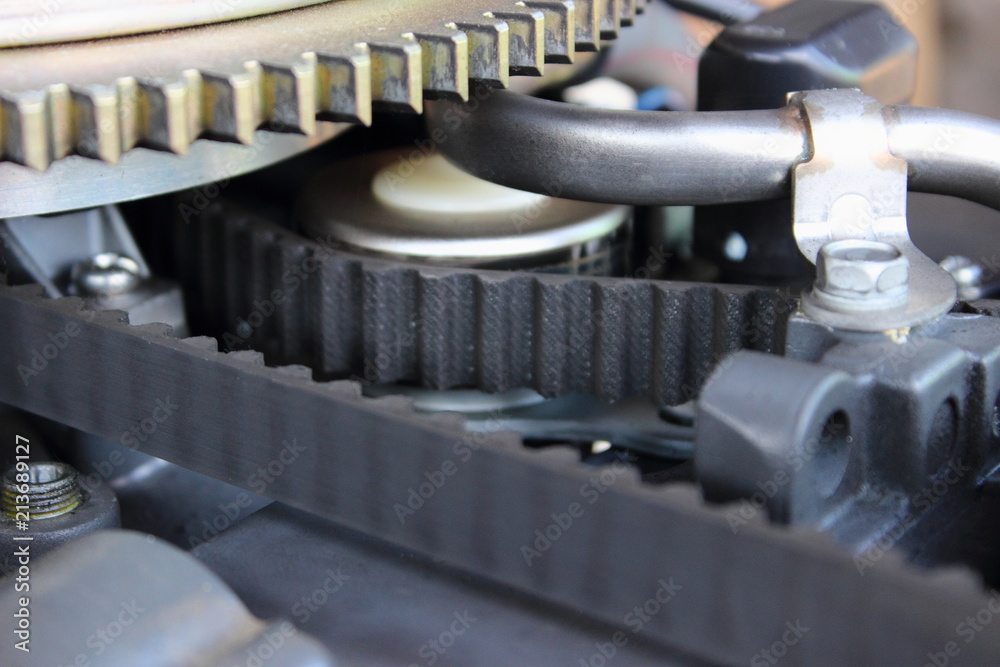 The outlet pipe of crankcase gases, the timing belt and the teeth of the flywheel closeup of four-stroke engine outboard boat motor