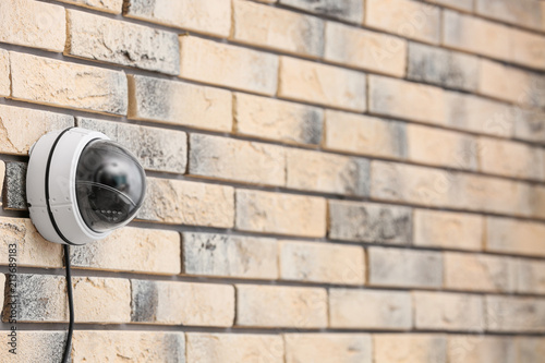 Modern security CCTV camera on brick wall