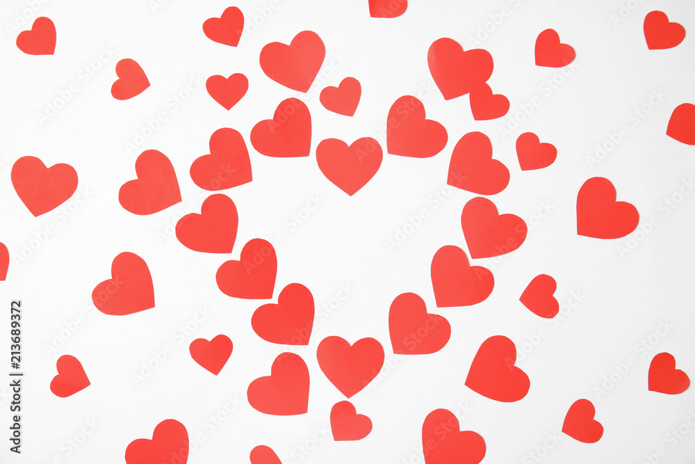 Composition made of small paper hearts on white background