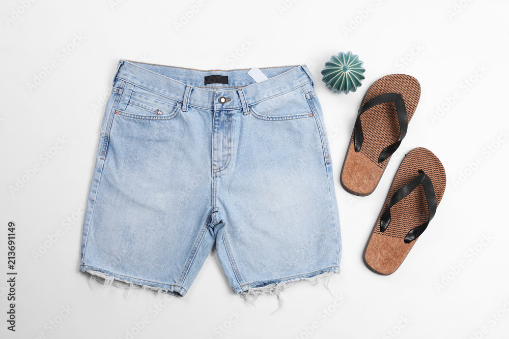 Flat lay composition with jean shorts and slippers on white background - obrazy, fototapety, plakaty 