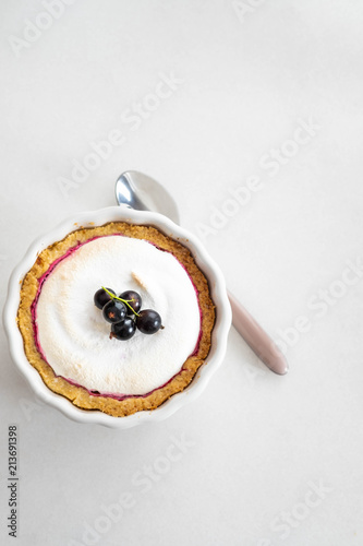 Homemade pie with summer berries and coffee closeup in a baking dish on a white table.Top view from above.