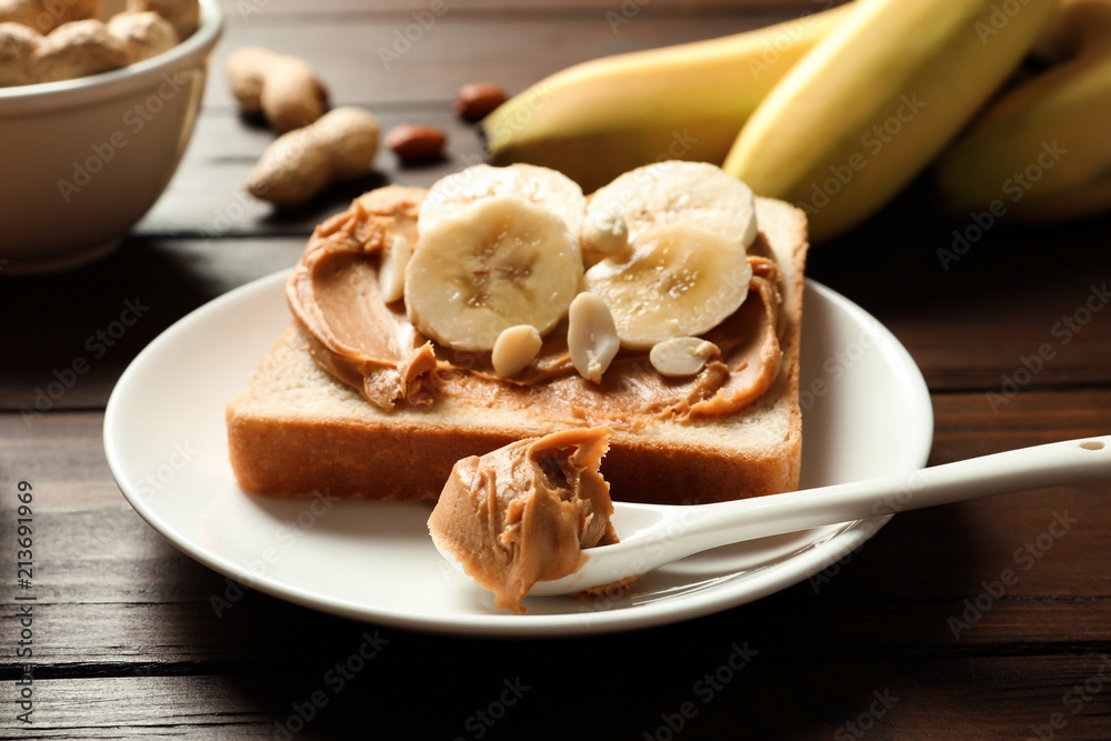 Toast bread with peanut butter and banana slices on wooden table, closeup Toast bread with peanut butter and banana slices on wooden table, closeup