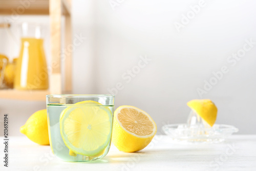 Glass of water with lemon slice on table