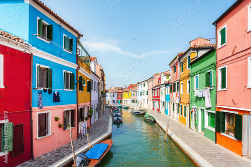 Street with colored houses on the island of Burano and with a canal in the middle, near Venice, Italy © LALSSTOCK