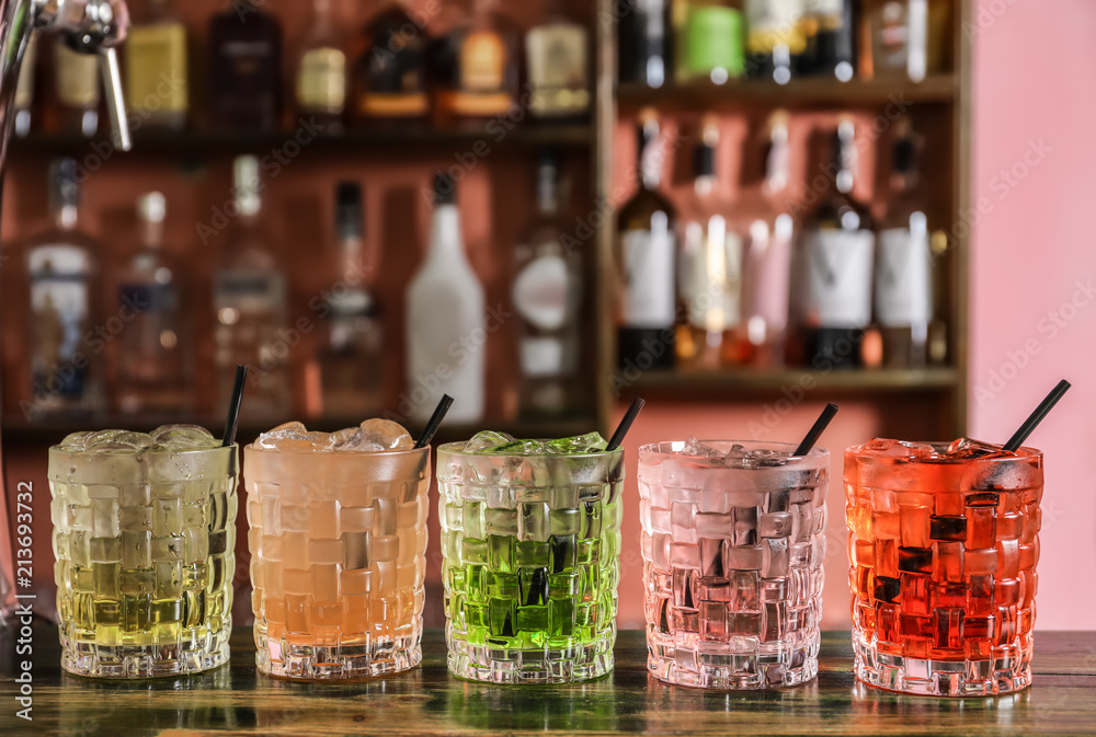 Glasses of delicious cocktails with ice on table Glasses of delicious cocktails with ice on table