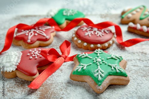 Tasty decorated Christmas cookies on wooden board, closeup