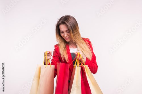 Portrait of surprised woman in red suit with shopping bags.
