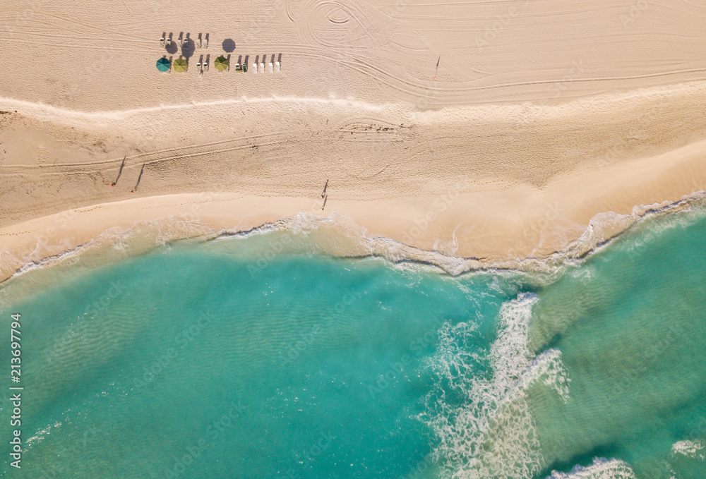 Top view of beautiful beach. Aerial drone shot of turquoise sea water at the beach - space for text. Caribbean seaside beach with turquoise water and big waves aerial view. Cancun beach aerial view. 