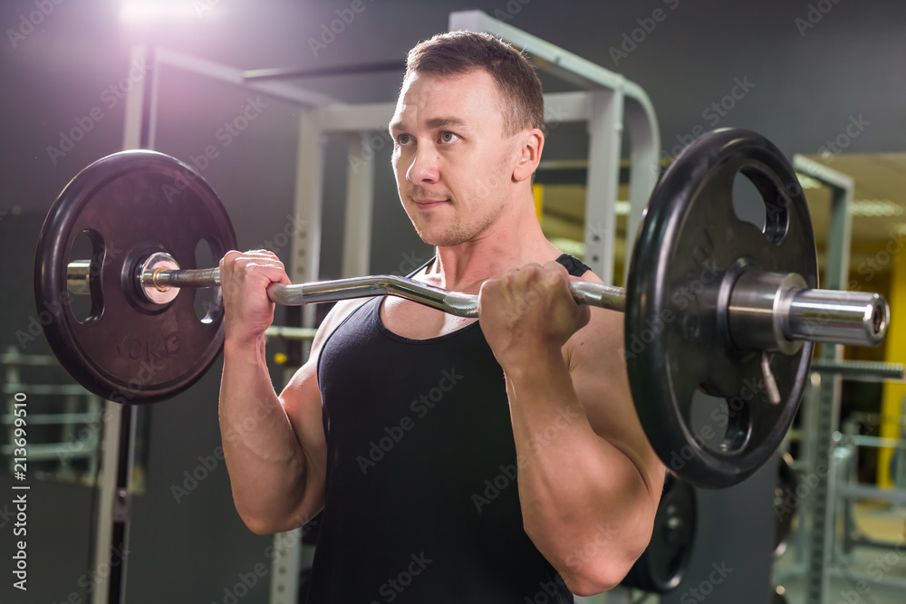 Powerful bodybuilder doing the exercises with barbell. Strength and motivation. Powerful bodybuilder doing the exercises with barbell. Strength and motivation.