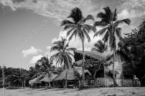 Wooden huts under palm trees from Nosy Be (Madagascar) paradise beach