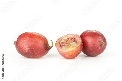Group of two whole one half of fresh red gooseberry hinnomaki variety isolated on white