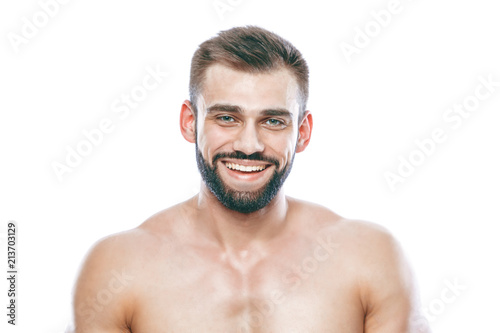 He stroked and touched his beard. A beautiful beard. Beautiful sporty guy male power. Fitness muscled in blue shorts. on isolated white background.