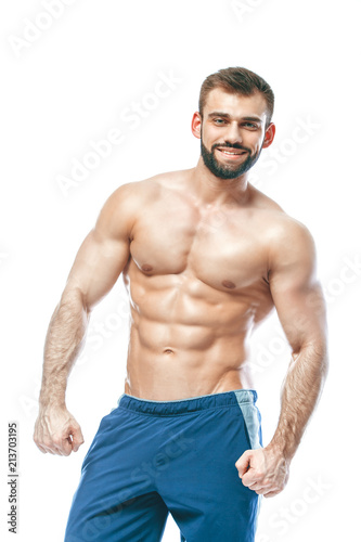 bodybuilder posing. Beautiful sporty guy male power. Fitness muscled in blue shorts. on isolated white background. Man with muscular torso. Strong Athletic Man Fitness Model Torso showing six pack abs