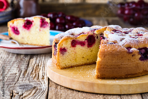 Obraz na plátně Cherry cake and slice of cake on rustic table
