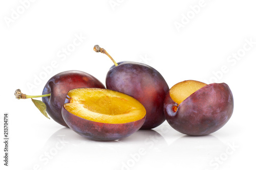 Group of three whole one half one piece of fresh violet-blue plum vibrant moyer variety isolated on white photo