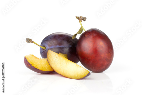 Group of two whole two slices of fresh violet-blue plum vibrant moyer variety isolated on white photo