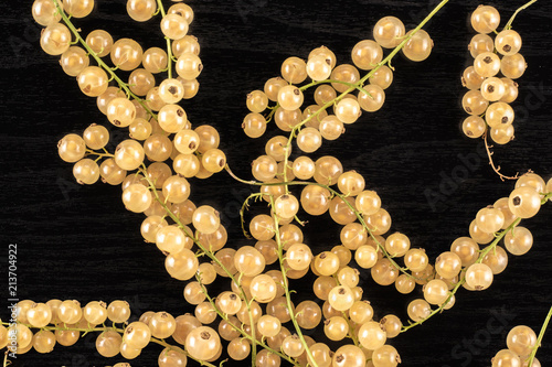 Lot of whole fresh white currant berry blanka variety flatlay on black wood photo