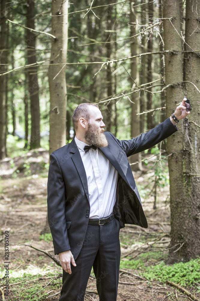 businessman makes selfie on the background of pine forest. businessman makes selfie on the background of pine forest.