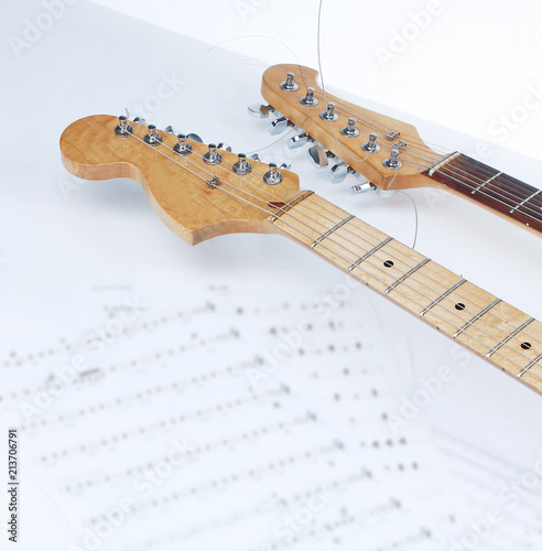 closeup .sheet music and guitar on a white background.