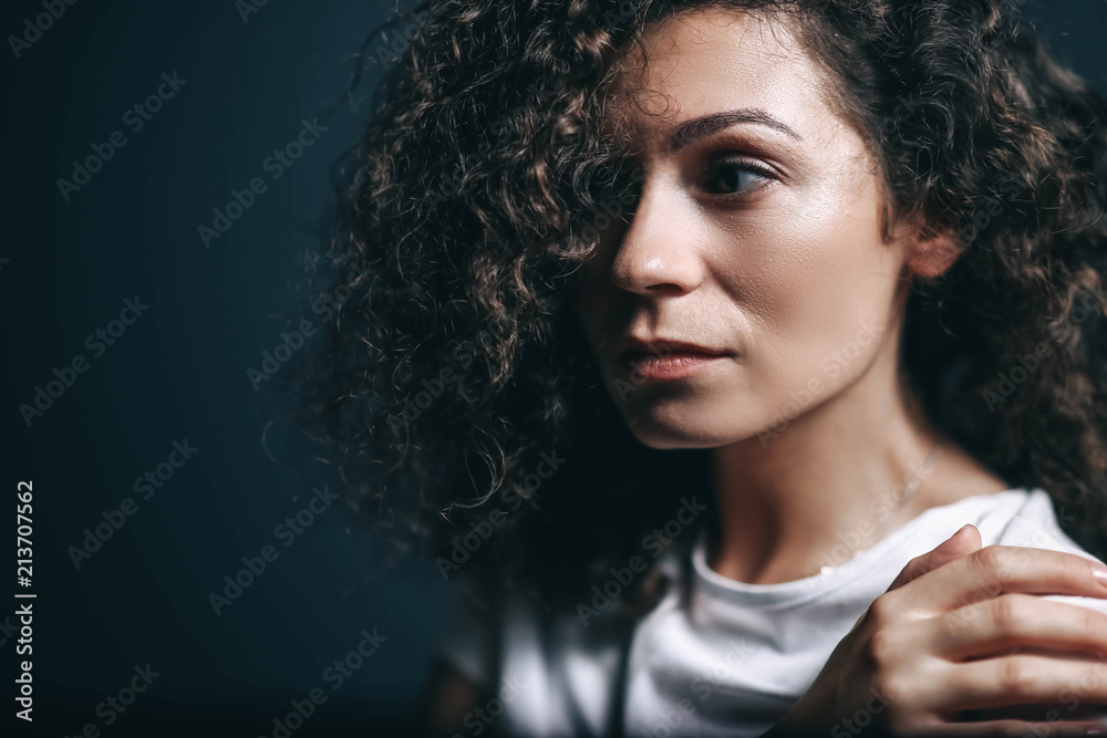 beautiful sexy curly young woman in studio on a dark background. posing of a charming brunette. beautiful sexy curly young woman in studio on a dark background. posing of a charming brunette.