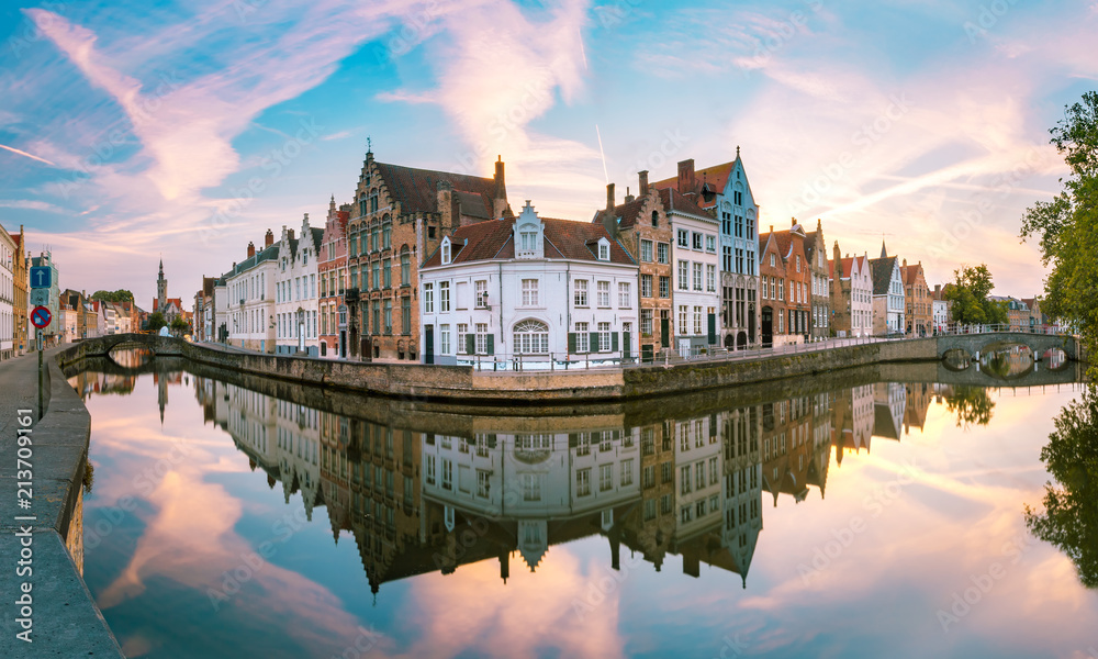 Canal Spiegelrei, bridges and tourist boat at sunset in Bruges, Belgium