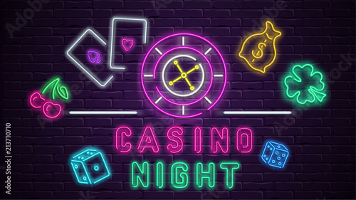 Colorful neon luminous casino night signboard on bricklaying wall.