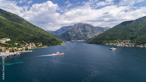 Aerial beautiful view from above to Kotor Bay and regular passenger ferry from Lepetane to Kamenari by a sunny afternoon photo
