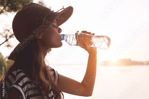Woman drinking water in summer morning sun