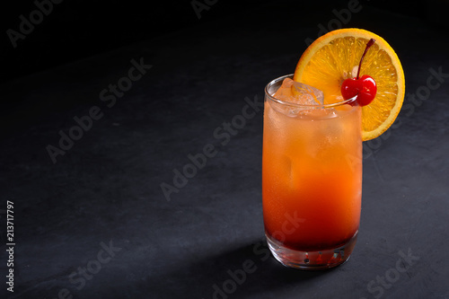 Tequila sunrise cocktail on dark stone background with space for your text. photo