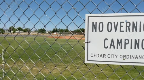 No camping sign on chain linked fence photo