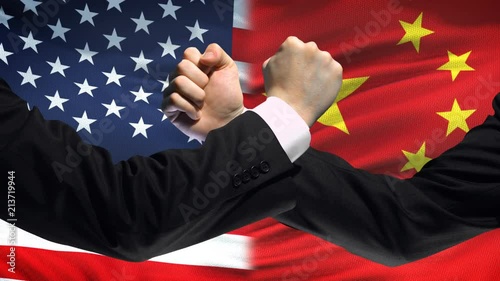 US vs China confrontation, countries disagreement, fists on flag background photo