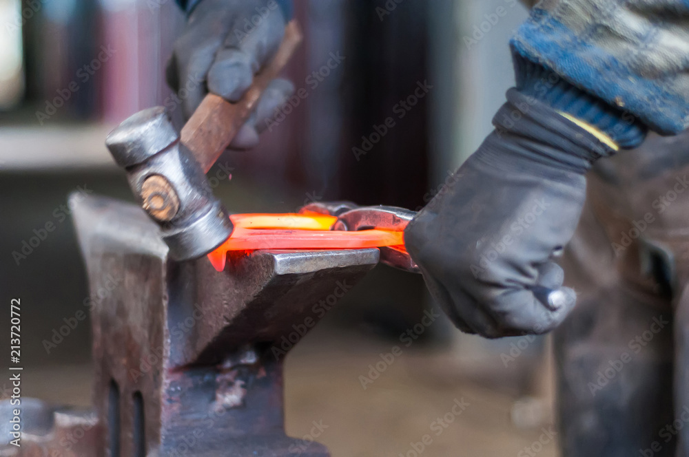 Blacksmith shaping the burning horse shoes