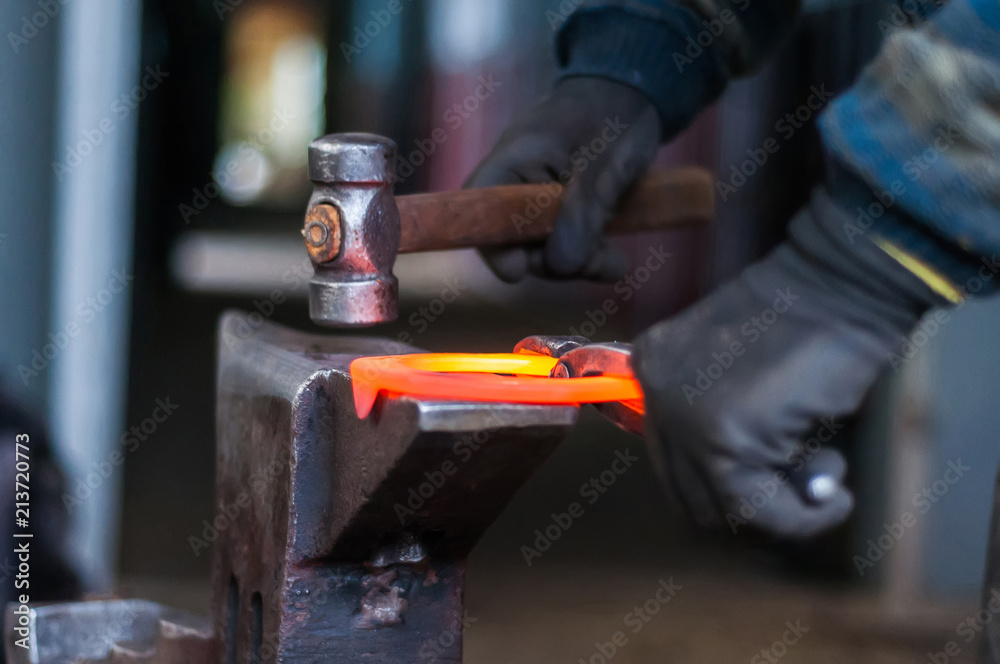 Blacksmith shaping the burning horse shoes