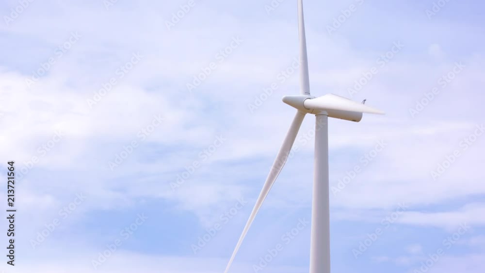 Wind turbine moving in the wind against a cloudy blue sky. Shot on a Blackmagic Ursa Mini Pro 4.6k with a Sigma 150-600mm f/5-6.3. Wind turbine moving in the wind against a cloudy blue sky. Shot on a Blackmagic Ursa Mini Pro 4.6k with a Sigma 150-600mm f/5-6.3.