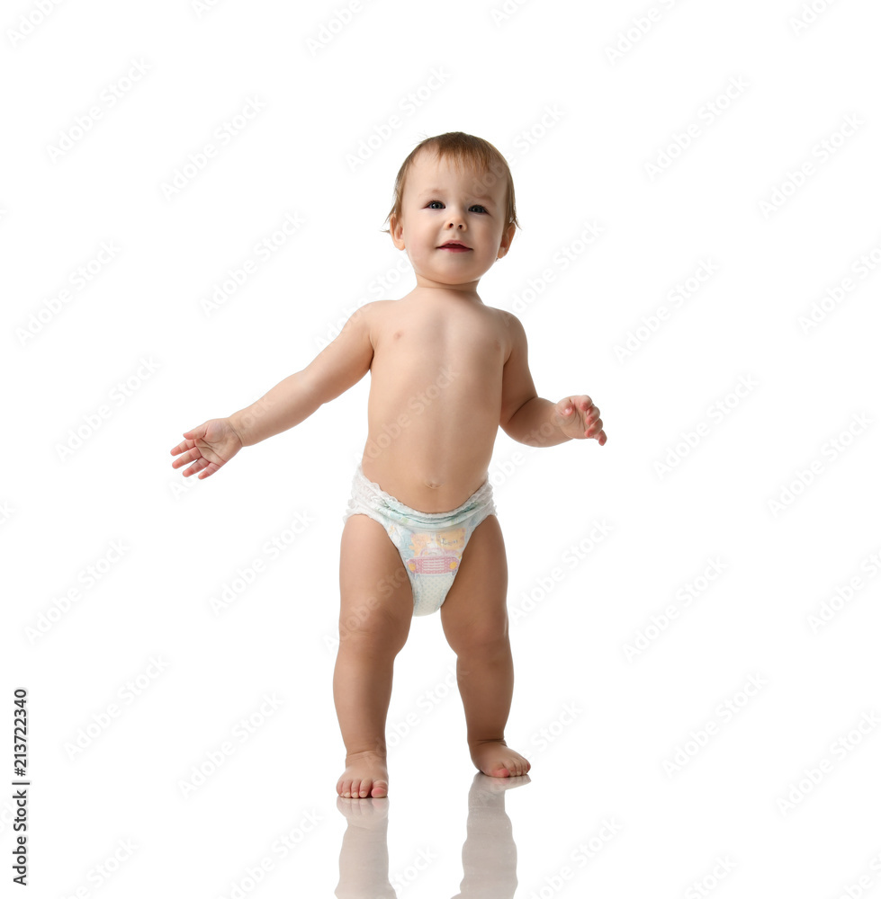 Infant child baby girl kid toddler in diaper make first steps Infant child baby girl kid toddler in diaper make first steps
