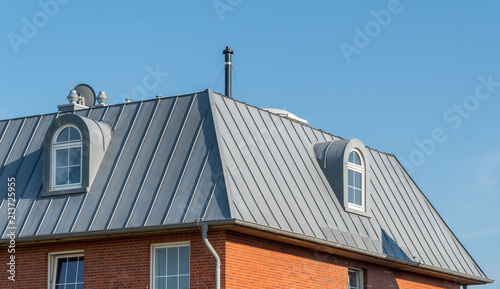 Dach und Gauben mit Fenstern eines Hauses aus Zinkblech