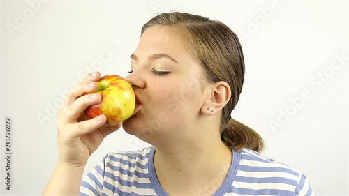 Beautiful young woman eating a red apple photo