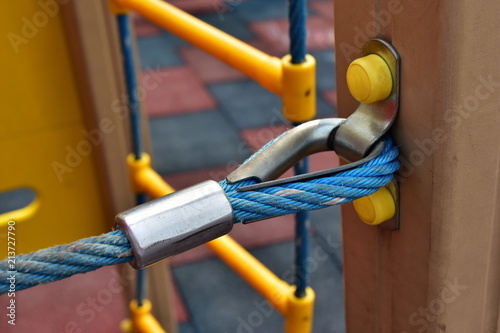 Thimble. Detail of fixing the blue nylon rope to the wooden beam on the structures of the children's playground