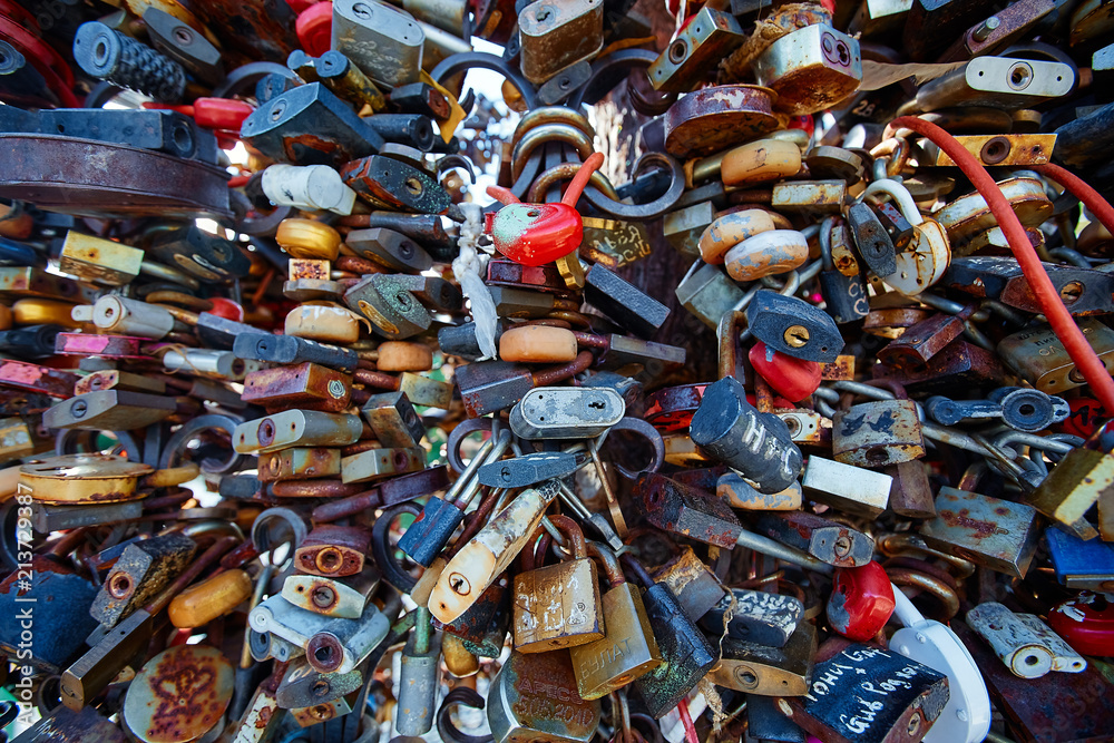 Closed wedding locks on a metal forged fence in the Park. Wedding details, Valentine's day, the concept of a strong and faithful marriage Closed wedding locks on a metal forged fence in the Park. Wedding details, Valentine's day, the concept of a strong and faithful marriage