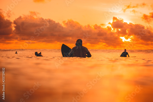 Canvas Print Surfers on line up in ocean at sunset or sunrise