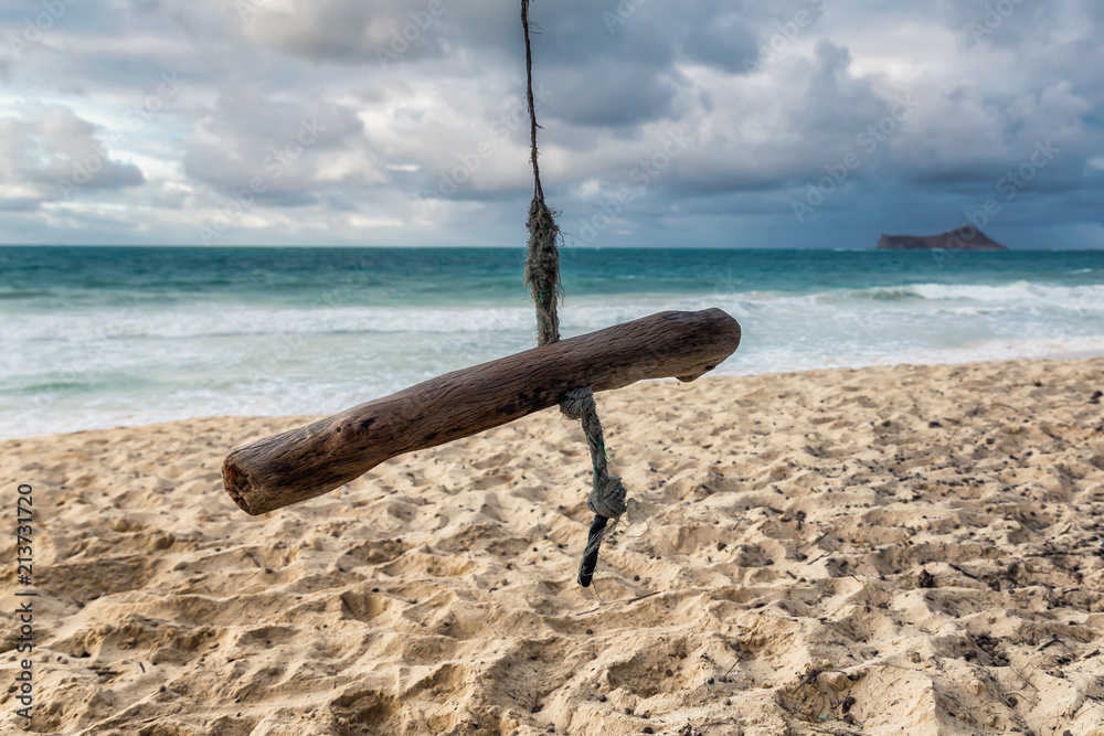 Wooden swing on a tropical beach of Oahu island, Hawaii Wooden swing on a tropical beach of Oahu island, Hawaii