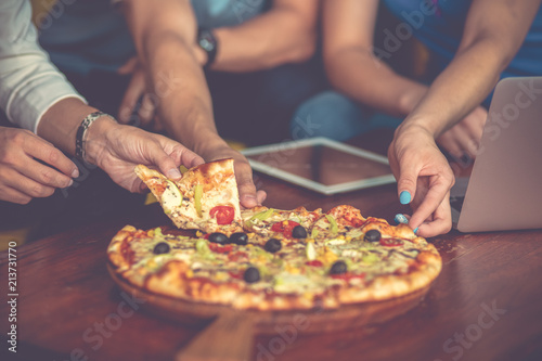 high angle view of young people eating pizza while working together