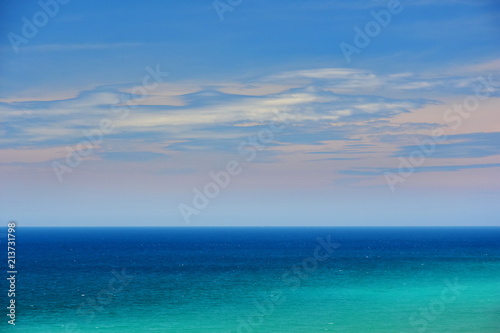 Beautiful clouds on blue sky over calm sea with sunlight reflection, Vietnam. Nha Trang. Tranquil sea harmony of calm water surface. Sunny sky and calm blue ocean. Vibrant sea with clouds on horizon