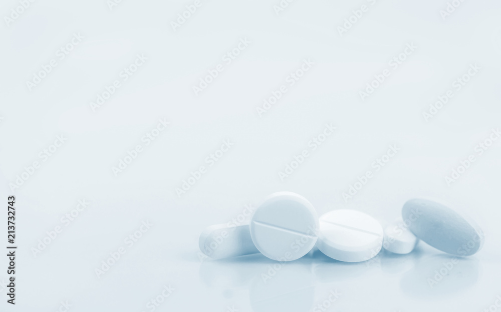 Pile of white round, oblong, and oval shape tablet pills isolated on white background. Pharmaceutical industry. Pharmacy or drugstore sign and symbol. Pharmacy background. Health and pharmacology.